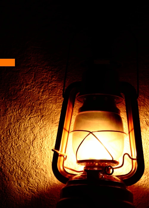 A small kerosene lamp glows brightly inside a dark rural Ugandan home, its warm light cutting through the shadows. The image symbolizes hope, learning, and resilience — a reminder of how even the faintest light can nurture a child’s dream. It reflects Baino Social Impact’s mission to bring lasting illumination through education and opportunity.