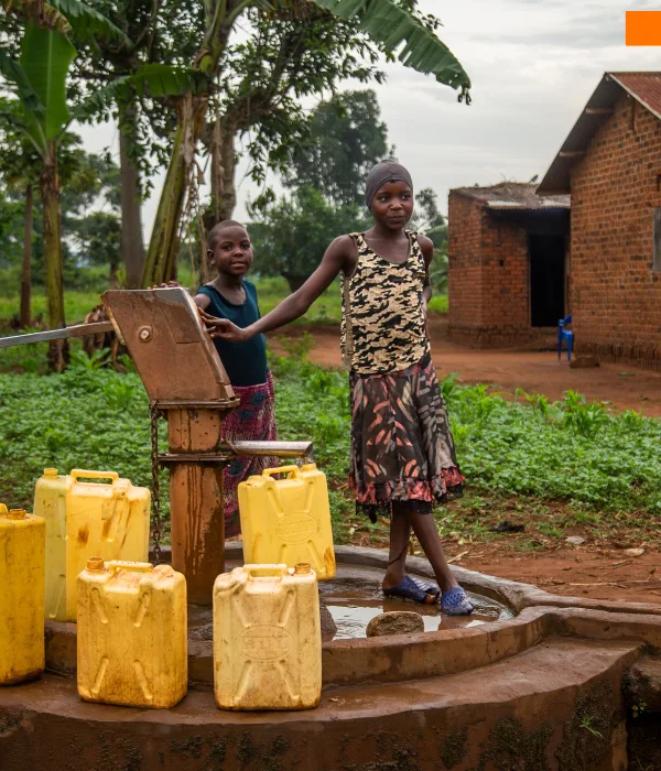 A young Ugandan girl stands by a village borehole, surrounded by yellow jerrycans beneath the soft light of day. Her calm presence amid the weight of daily chores tells a deeper story — of countless obstacles faced and quiet courage sustained. The image reflects Baino Social Impact’s mission to transform such everyday struggles into stepping stones toward education, dignity, and a reclaimed future.