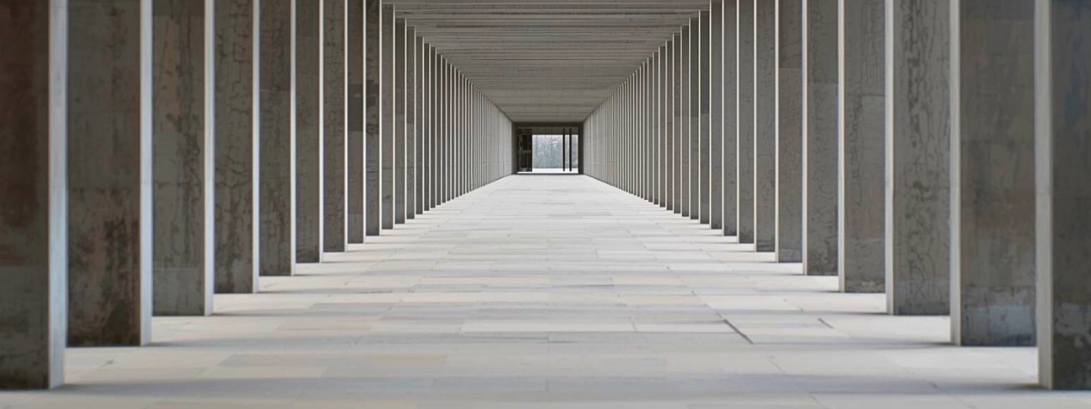 A corridor with repeating structural elements, conveying rhythm, order, and steady continuity.