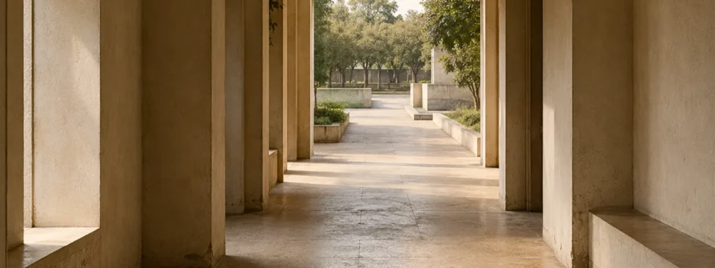 Architectural transition space with long openings and muted natural outdoor light, suggesting movement that has begun but remains structurally unresolved over time.